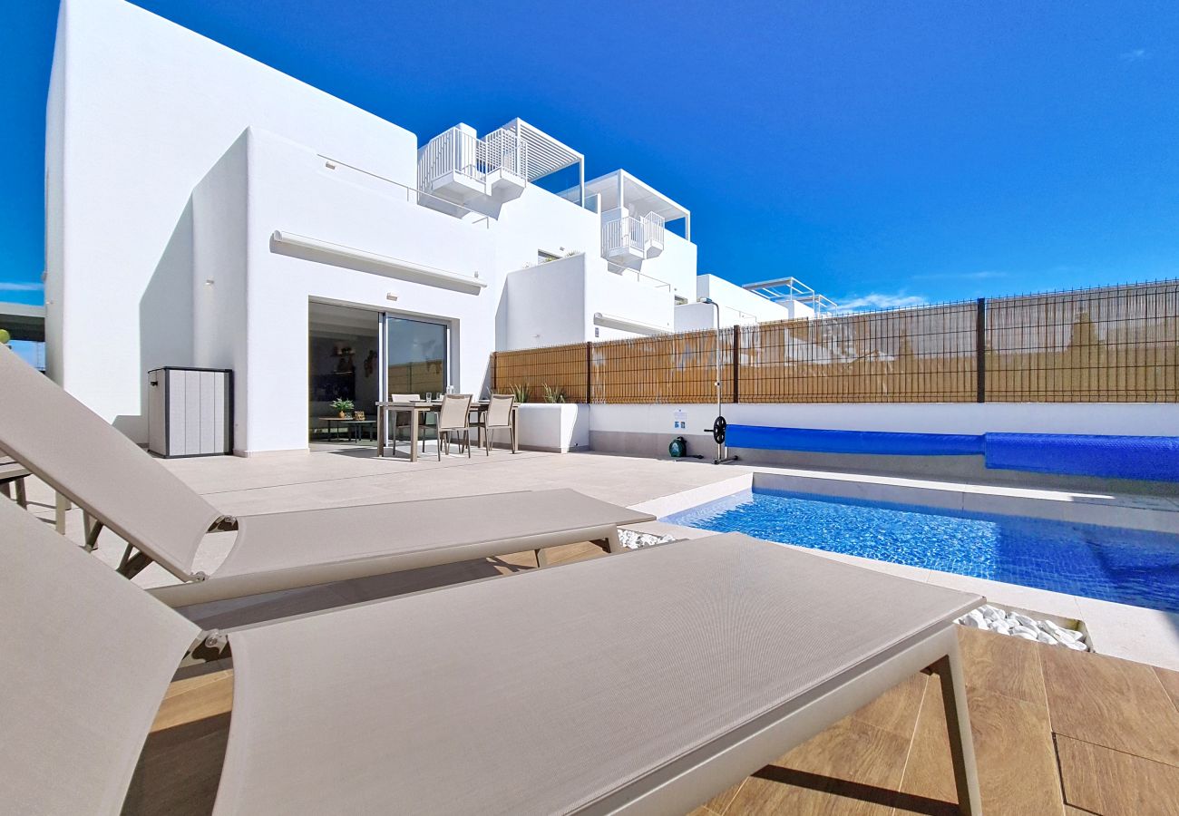 Modern 3-bedroom villa in Los Alcázares with private L-shaped pool and outdoor dining area.