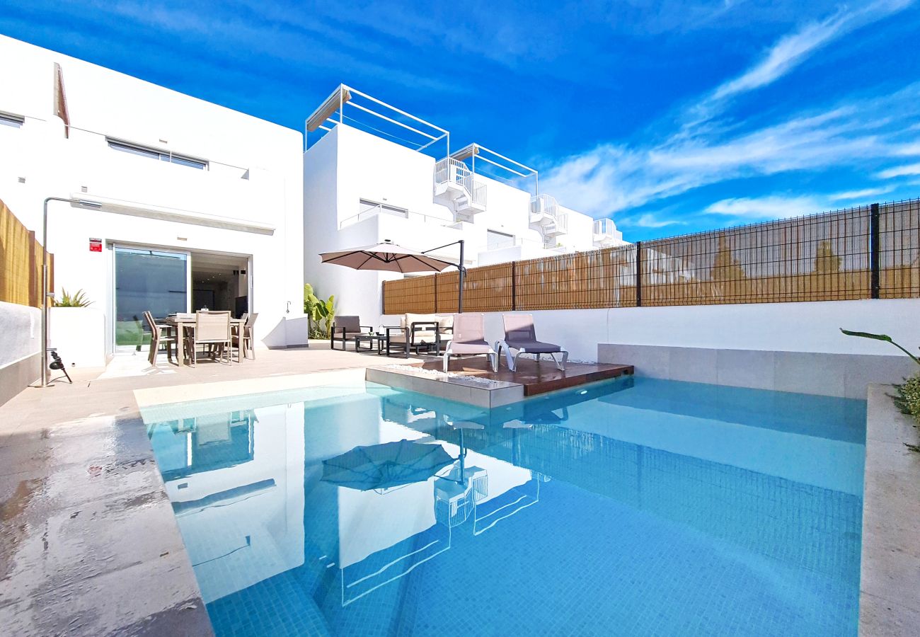Modern 3-bedroom villa in Los Alcázares with private L-shaped pool and outdoor dining area.